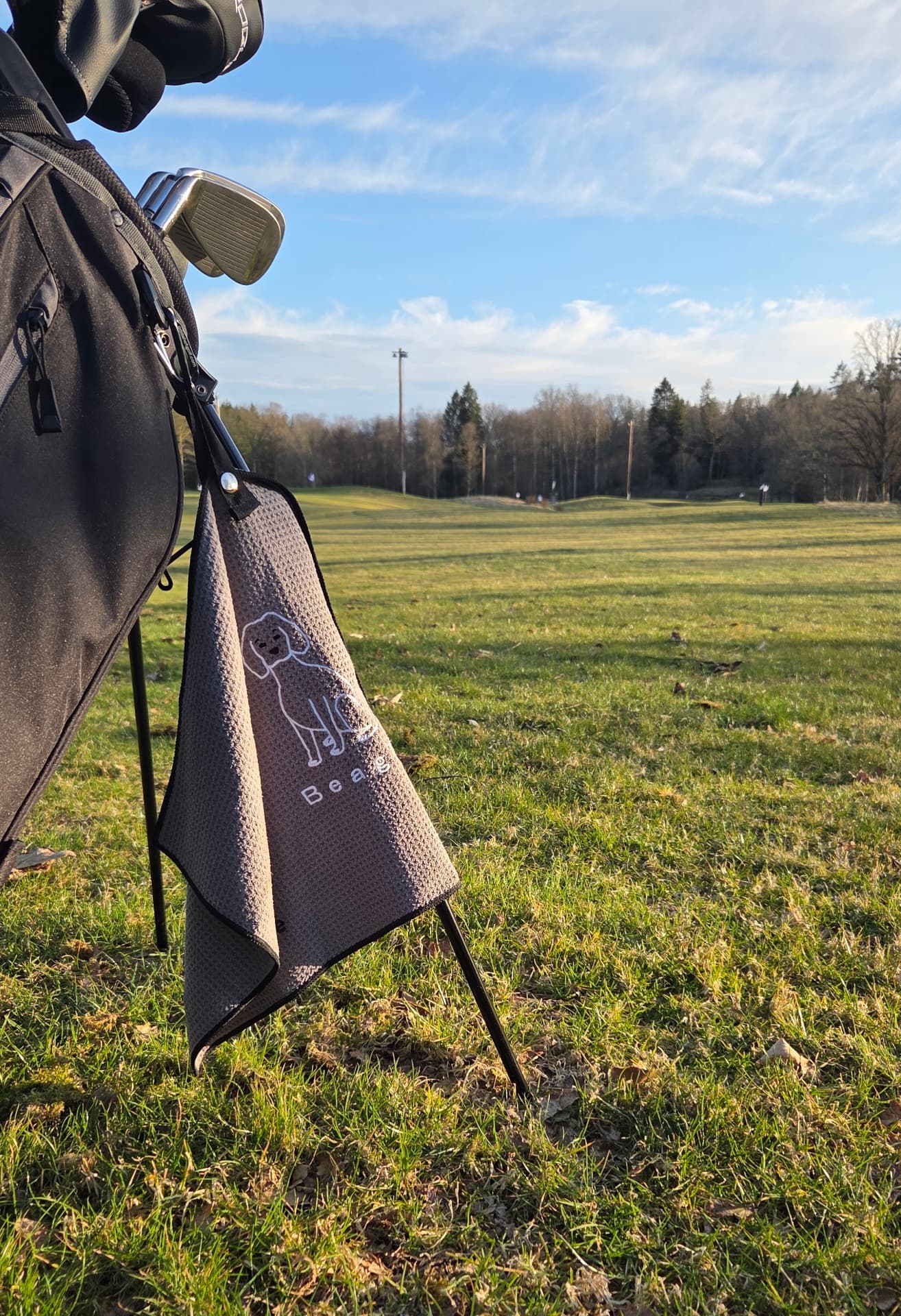 Broderad golfhandduk på en golfbag ute på banan